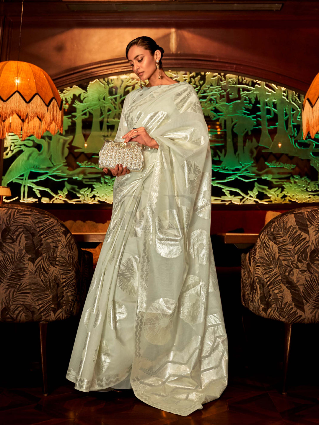 This Ivory White–Silver Organza saree features subtle silver woven detailing for a dreamy, feather-light silhouette ideal for receptions, photoshoots, and elegant gatherings. Designed for lightness, movement, and soft glamour. SKU 255003. This Ivory White–Silver Organza saree features subtle silver woven detailing for a dreamy, feather-light silhouette ideal for receptions, photoshoots, and elegant gatherings. Designed for lightness, movement, and soft glamour. SKU 255003.