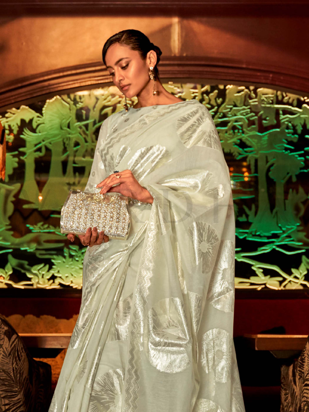 This Ivory White–Silver Organza saree features subtle silver woven detailing for a dreamy, feather-light silhouette ideal for receptions, photoshoots, and elegant gatherings. Designed for lightness, movement, and soft glamour. SKU 255003. This Ivory White–Silver Organza saree features subtle silver woven detailing for a dreamy, feather-light silhouette ideal for receptions, photoshoots, and elegant gatherings. Designed for lightness, movement, and soft glamour. SKU 255003.