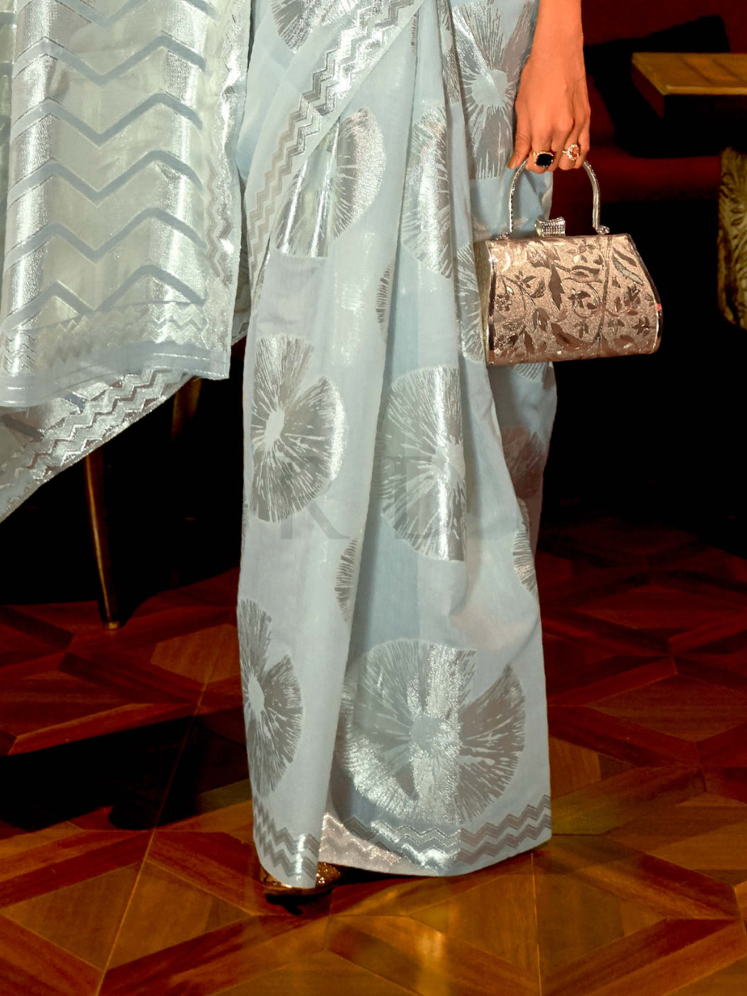 This Sky Blue–Silver Organza saree features subtle silver woven detailing for a dreamy, feather-light silhouette ideal for receptions, photoshoots, and elegant gatherings. Designed for lightness, movement, and soft glamour. SKU 255004. This Sky Blue–Silver Organza saree features subtle silver woven detailing for a dreamy, feather-light silhouette ideal for receptions, photoshoots, and elegant gatherings. Designed for lightness, movement, and soft glamour. SKU 255004.