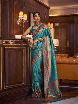 This luxurious Teal Blue–Copper Kanjivaram Silk saree features classic woven zari work with contrast pallu and ornate detailing. Elegant wedding attire with heritage style and timeless drape. SKU 271001. This luxurious Teal Blue–Copper Kanjivaram Silk saree features classic woven zari work with contrast pallu and ornate detailing. Elegant wedding attire with heritage style and timeless drape. SKU 271001.