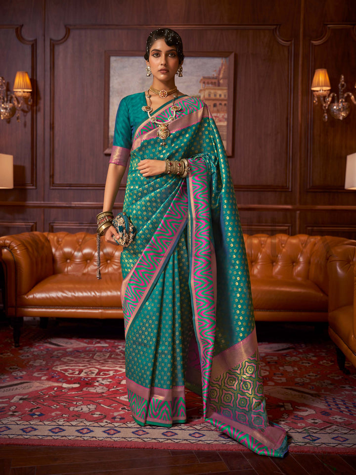 This luxurious Emerald Teal–Pink Kanjivaram Silk saree features classic woven zari work with contrast pallu and ornate detailing. Elegant wedding attire with heritage style and timeless drape. SKU 271006. This luxurious Emerald Teal–Pink Kanjivaram Silk saree features classic woven zari work with contrast pallu and ornate detailing. Elegant wedding attire with heritage style and timeless drape. SKU 271006.