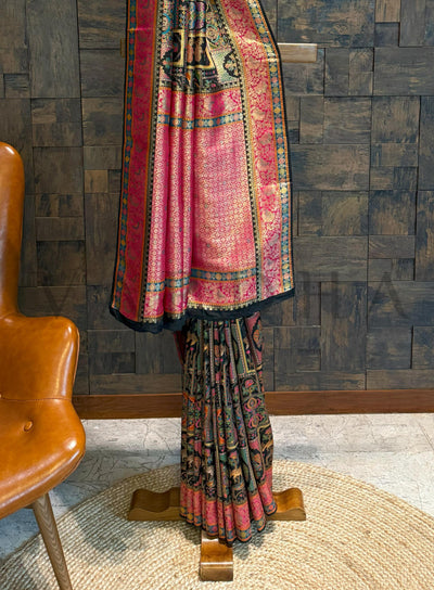 Traditional saree on a wooden stand against a textured wall.
