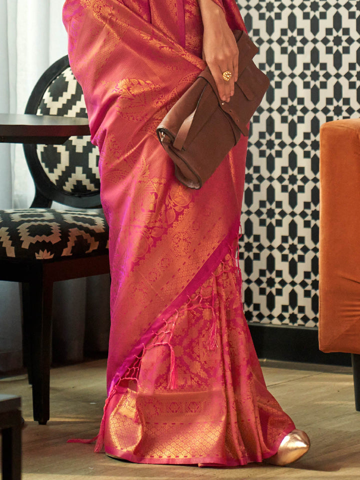 Glossy magenta pink silk saree in kanjivaram weave with golden pallu highlights. Heritage bridal saree in pink and magenta silk with detailed woven zari patterns.