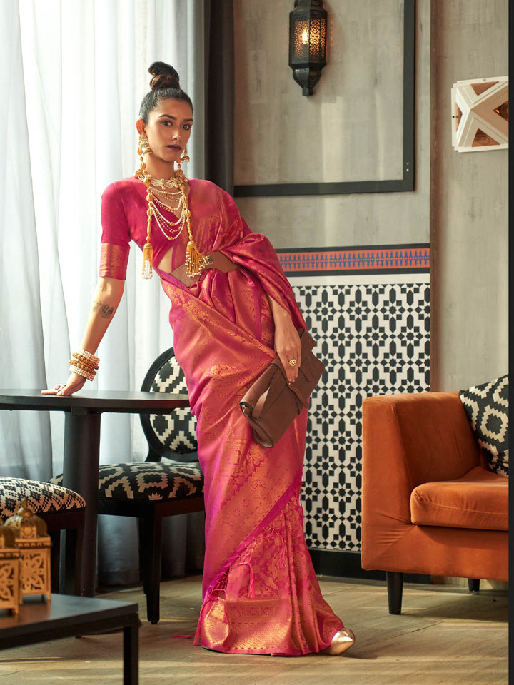 Rose pink and magenta kanjivaram silk saree with intricate golden zari weave, styled for weddings. Two-tone bridal silk saree in rose pink and magenta with golden zari motifs and classic pallu.