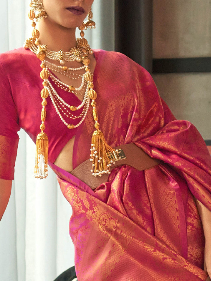 Classic kanjivaram wedding saree in magenta rose hues, styled with gold accessories. Traditional silk saree in rose pink and magenta with heavy golden zari weaving and pallu tassels.