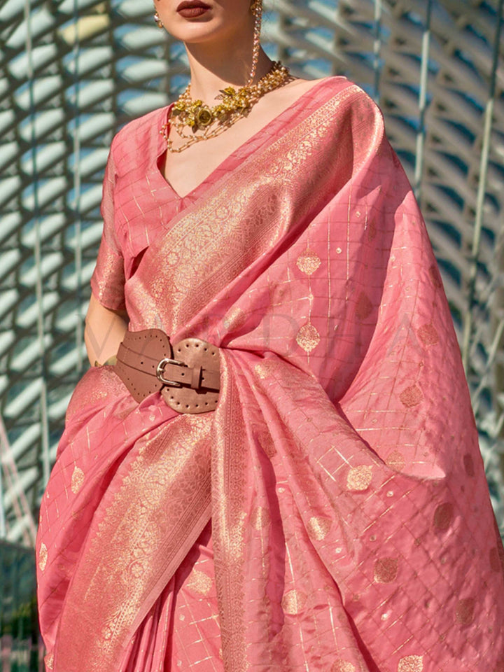Coral Peach Katan silk saree with Gold zari detailing, featuring checks handloom weaving, designer blouse and tasselled pallu — a perfect fit for wedding and reception night. Styled with modern belts, hats, and accessories to blend heritage and couture elegance. This image captures the zoomed texture view illustrating fabric weave and print clarity, ideal for visualizing festive elegance, designer appeal, and modern styling inspiration. Perfect for online shoppers seeking detailed previews before purchase, 