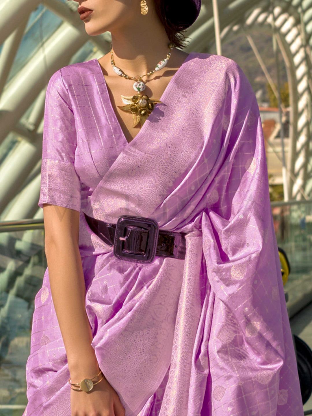 Orchid Mauve Katan silk saree with Ivory Zari zari detailing, featuring checks handloom weaving, designer blouse and tasselled pallu — a perfect fit for sangeet and designer cocktail. Styled with modern belts, hats, and accessories to blend heritage and couture elegance. This image captures the zoomed texture view illustrating fabric weave and print clarity, ideal for visualizing festive elegance, designer appeal, and modern styling inspiration. Perfect for online shoppers seeking detailed previews before p