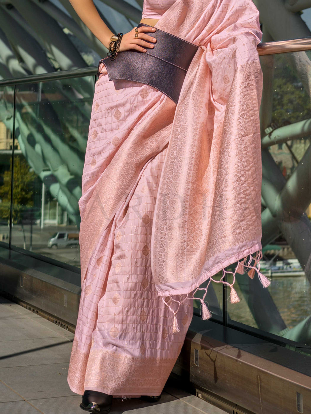Blush Nude Katan silk saree with Ivory zari detailing, featuring checks handloom weaving, designer blouse and tasselled pallu — a perfect fit for party-wear and anniversary glam. Styled with modern belts, hats, and accessories to blend heritage and couture elegance. This image captures the back drape focus revealing pallu finesse and motif richness, ideal for visualizing festive elegance, designer appeal, and modern styling inspiration. Perfect for online shoppers seeking detailed previews before purchase, 