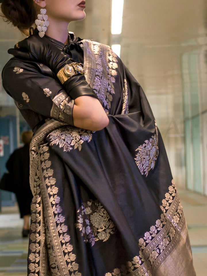 Jet Black silk saree with Old Gold Zari zari and Antique Beige floral motifs, styled with contrast blouse, handloom weaving, festive-ready look with cinematic silhouette and bold accessories — ideal for events and grand celebrations. This image captures the zoomed texture view illustrating fabric weave and print clarity, ideal for visualizing festive elegance, designer appeal, and modern styling inspiration. Perfect for online shoppers seeking detailed previews before purchase, enhancing saree visual mercha