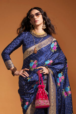 Navy Blue pure satin silk saree with multicolour floral handloom weaving and rich zari border. Styled for wedding and perfect for reception night, blending regal silk elegance with festive florals. This image captures the front drape view highlighting pallu fall and pleats alignment, ideal for visualizing festive elegance, designer appeal, and modern styling inspiration. Perfect for online shoppers seeking detailed previews before purchase, enhancing saree visual merchandising and SEO-rich product display s