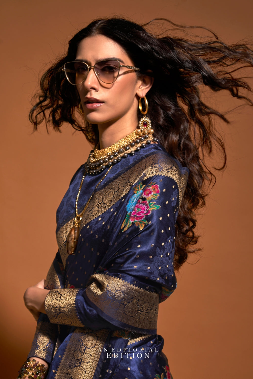 Navy Blue pure satin silk saree with multicolour floral handloom weaving and rich zari border. Styled for wedding and perfect for reception night, blending regal silk elegance with festive florals. This image captures the back drape focus revealing pallu finesse and motif richness, ideal for visualizing festive elegance, designer appeal, and modern styling inspiration. Perfect for online shoppers seeking detailed previews before purchase, enhancing saree visual merchandising and SEO-rich product display str