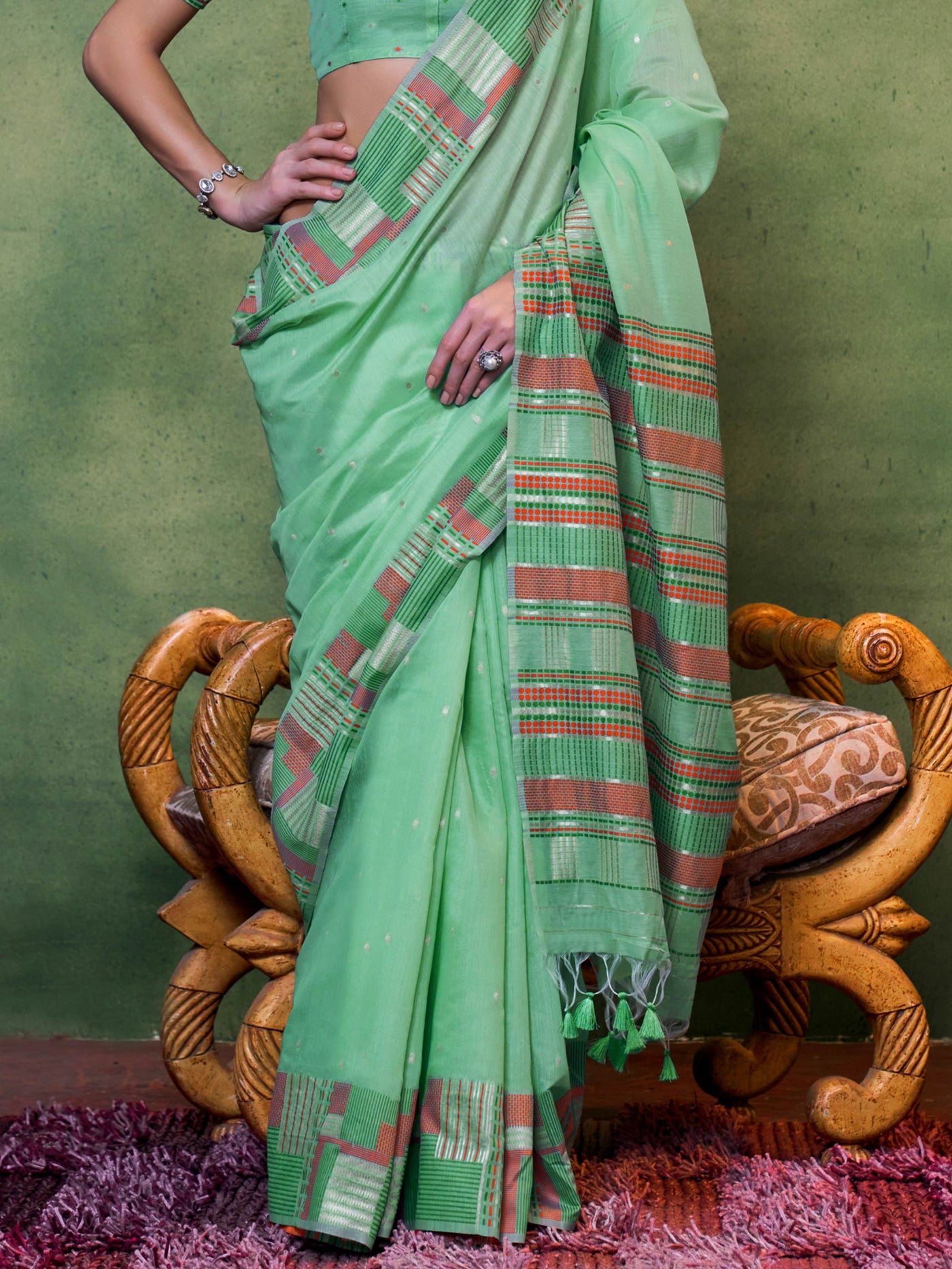 Elegant daywear saree in mint green with artistic multicolored pallu patterns and woven texture. Mint green woven saree styled with contrast accessories for a rooted and refined ethnic look.