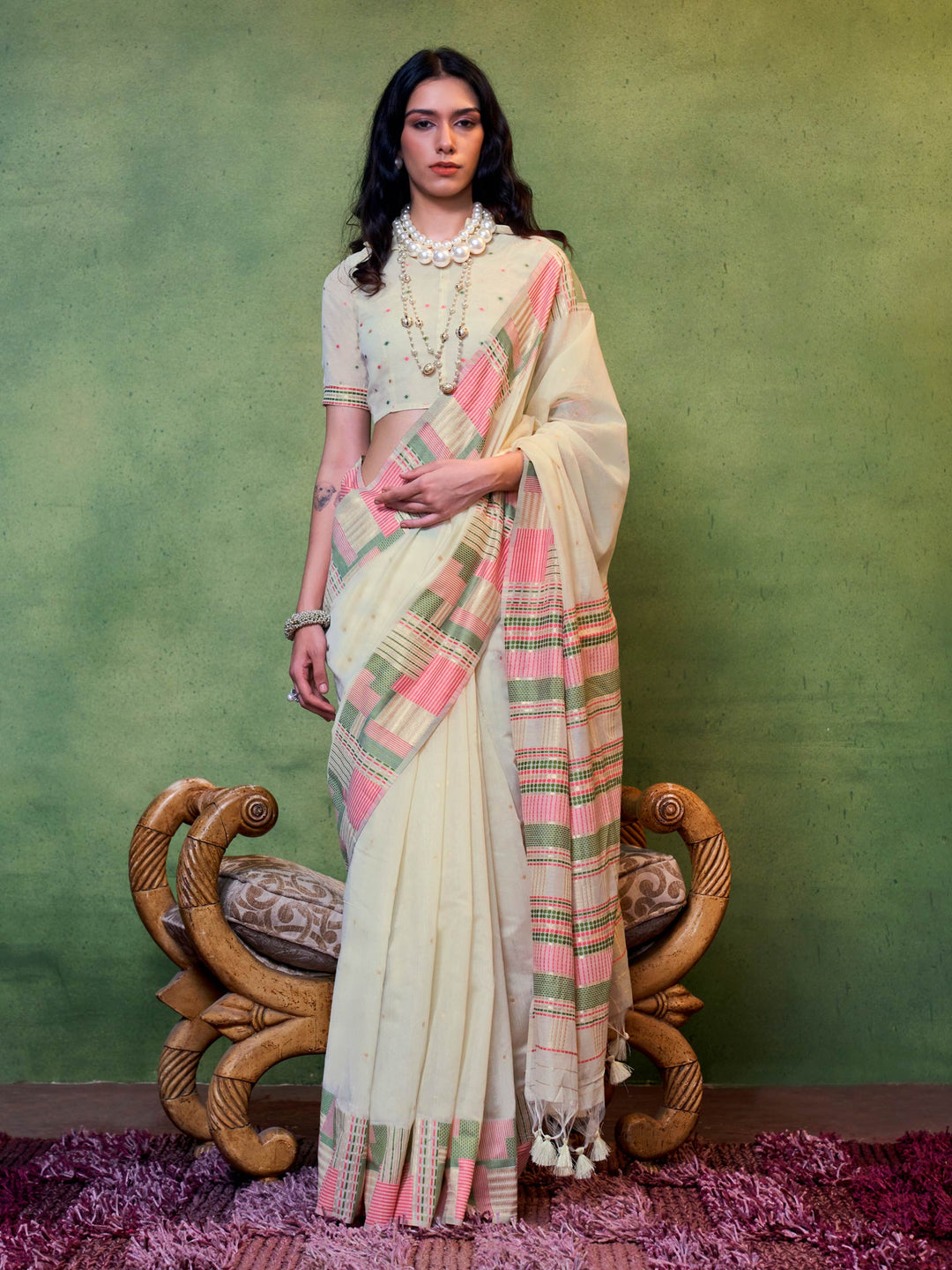 Ivory–Pink cotton spun saree with floral check border and woven pallu, perfect for festive occasions. Elegant cotton saree in Ivory–Pink with breathable drape and soft floral borders.