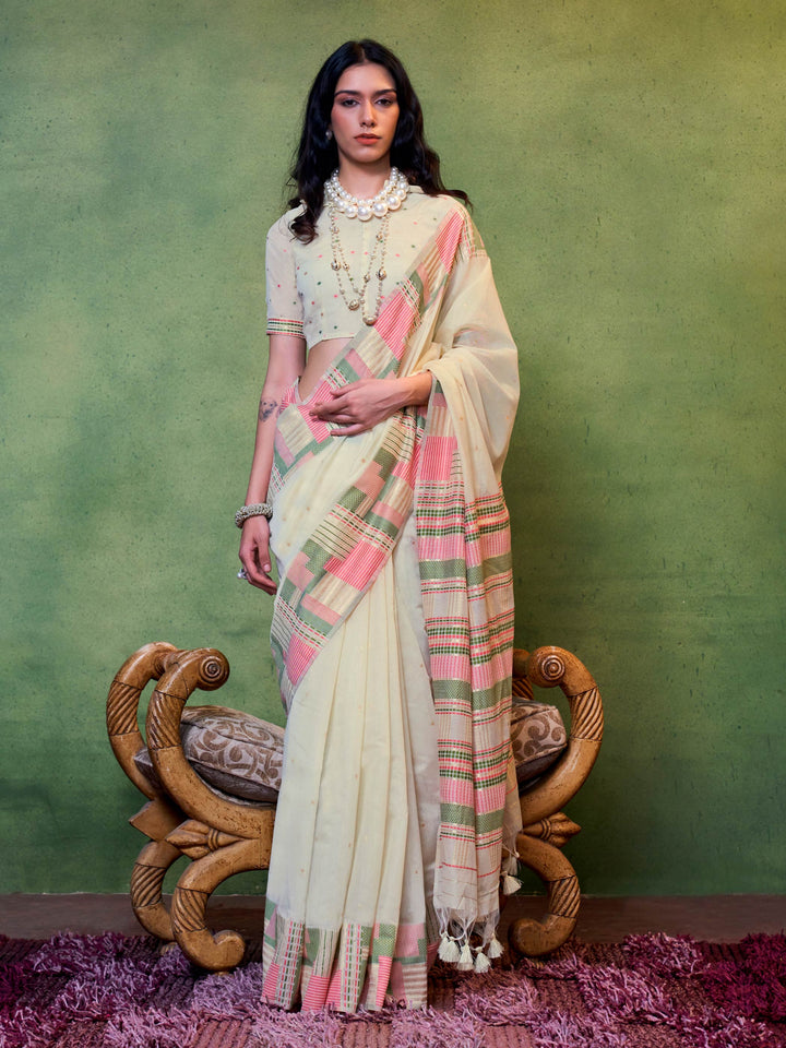 Ivory–Pink cotton spun saree with floral check border and woven pallu, perfect for festive occasions. Elegant cotton saree in Ivory–Pink with breathable drape and soft floral borders.