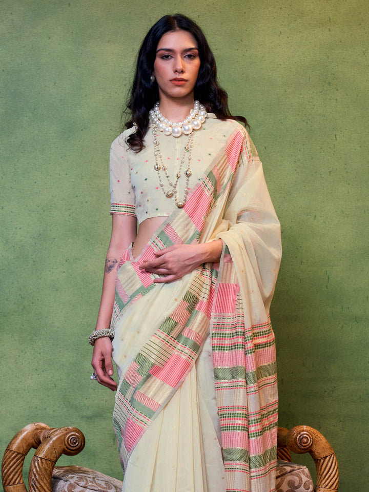 Ivory–Pink festive saree featuring woven checks, tassel finish, and soft pastel elegance. Pastel Ivory–Pink cotton saree for cultural daywear with minimalistic woven detailing.
