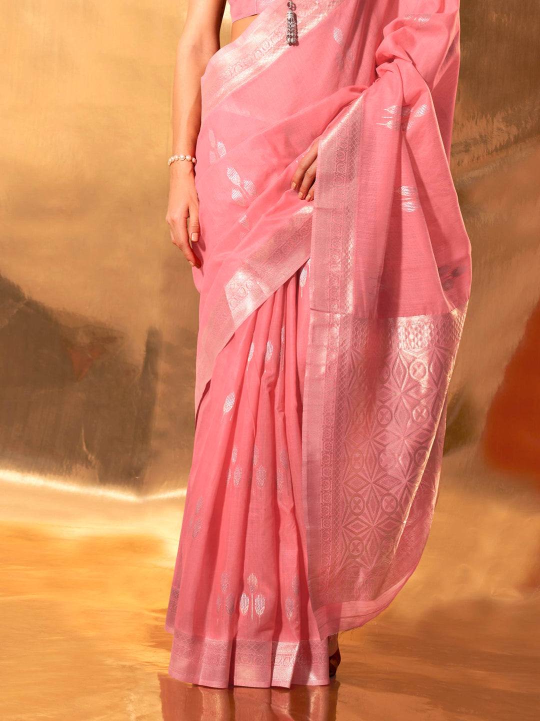Lightweight rose pink drape with floral silver woven patterns across pallu and border. Daywear-ready linen cotton saree in pink with woven floral design and contrast blouse piece.