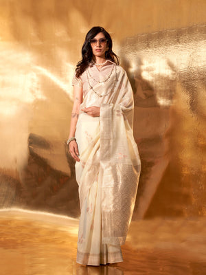 Ivory–Beige linen cotton saree with woven floral border and silver/golden pallu design. Soft Ivory–Beige saree in linen cotton featuring elegant woven motifs and jacquard styling.