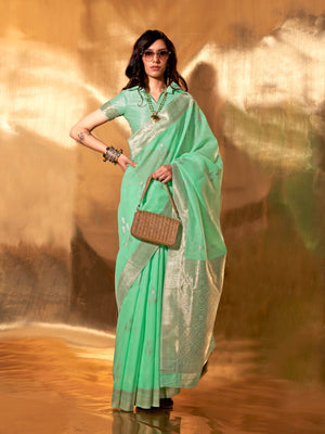 Sea Green–Silver linen cotton saree with woven floral border and silver/golden pallu design. Soft Sea Green–Silver saree in linen cotton featuring elegant woven motifs and jacquard styling.