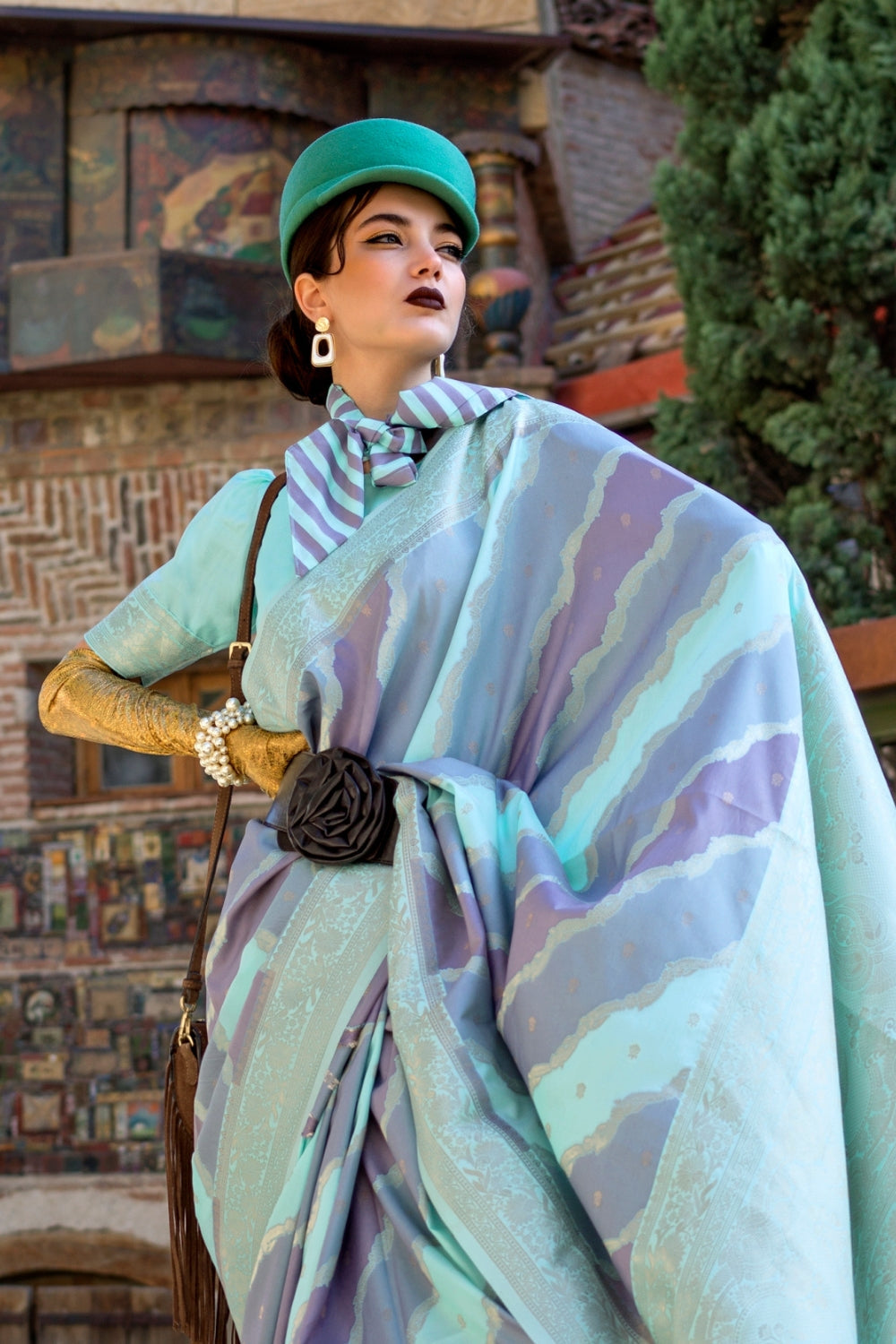 Teal Blue and Lavender Kimbus saree in rangkaat katan silk, designed with wave-striped motifs and a dramatic tassel pallu. Best styled for bollywood and fashion-forward red carpet celebrations. This image captures the side angle view showcasing blouse styling and zari border detail, ideal for visualizing festive elegance, designer appeal, and modern styling inspiration. Perfect for online shoppers seeking detailed previews before purchase, enhancing saree visual merchandising and SEO-rich product display st