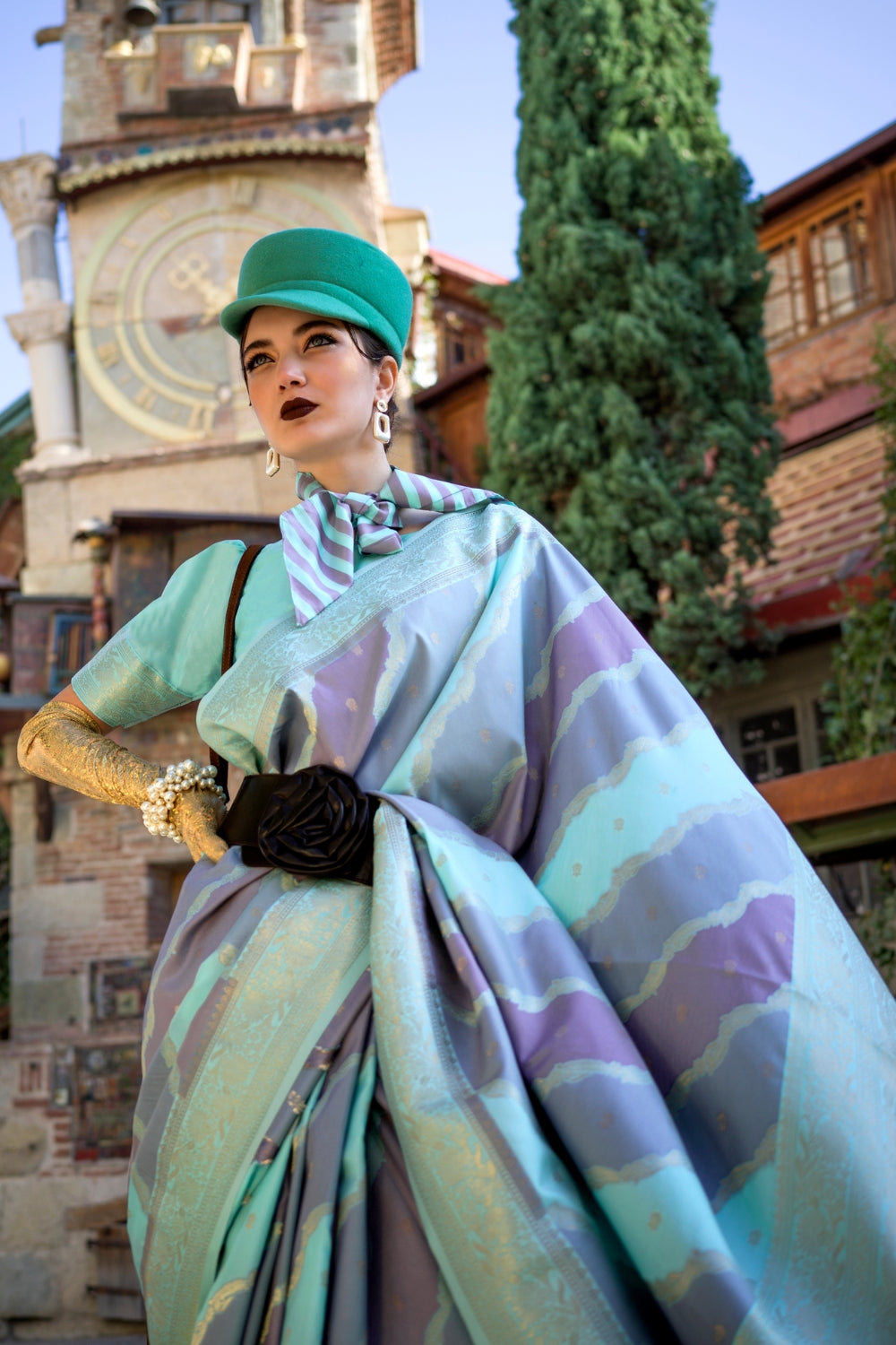 Teal Blue and Lavender Kimbus saree in rangkaat katan silk, designed with wave-striped motifs and a dramatic tassel pallu. Best styled for bollywood and fashion-forward red carpet celebrations. This image captures the zoomed texture view illustrating fabric weave and print clarity, ideal for visualizing festive elegance, designer appeal, and modern styling inspiration. Perfect for online shoppers seeking detailed previews before purchase, enhancing saree visual merchandising and SEO-rich product display str