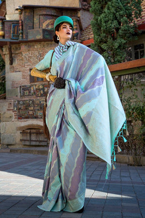 Teal Blue and Lavender Kimbus saree in rangkaat katan silk, designed with wave-striped motifs and a dramatic tassel pallu. Best styled for bollywood and fashion-forward red carpet celebrations. This image captures the front drape view highlighting pallu fall and pleats alignment, ideal for visualizing festive elegance, designer appeal, and modern styling inspiration. Perfect for online shoppers seeking detailed previews before purchase, enhancing saree visual merchandising and SEO-rich product display strat