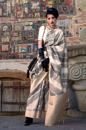 Stone Beige and Taupe Kimbus saree in rangkaat katan silk, designed with wave-striped motifs and a dramatic tassel pallu. Best styled for wedding and fashion-forward engagement celebrations. This image captures the front drape view highlighting pallu fall and pleats alignment, ideal for visualizing festive elegance, designer appeal, and modern styling inspiration. Perfect for online shoppers seeking detailed previews before purchase, enhancing saree visual merchandising and SEO-rich product display strategy