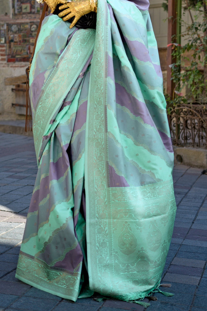 Mint and Mauve Kimbus saree in rangkaat katan silk, designed with wave-striped motifs and a dramatic tassel pallu. Best styled for sangeet and fashion-forward fusion ceremony celebrations. This image captures the back drape focus revealing pallu finesse and motif richness, ideal for visualizing festive elegance, designer appeal, and modern styling inspiration. Perfect for online shoppers seeking detailed previews before purchase, enhancing saree visual merchandising and SEO-rich product display strategy.   