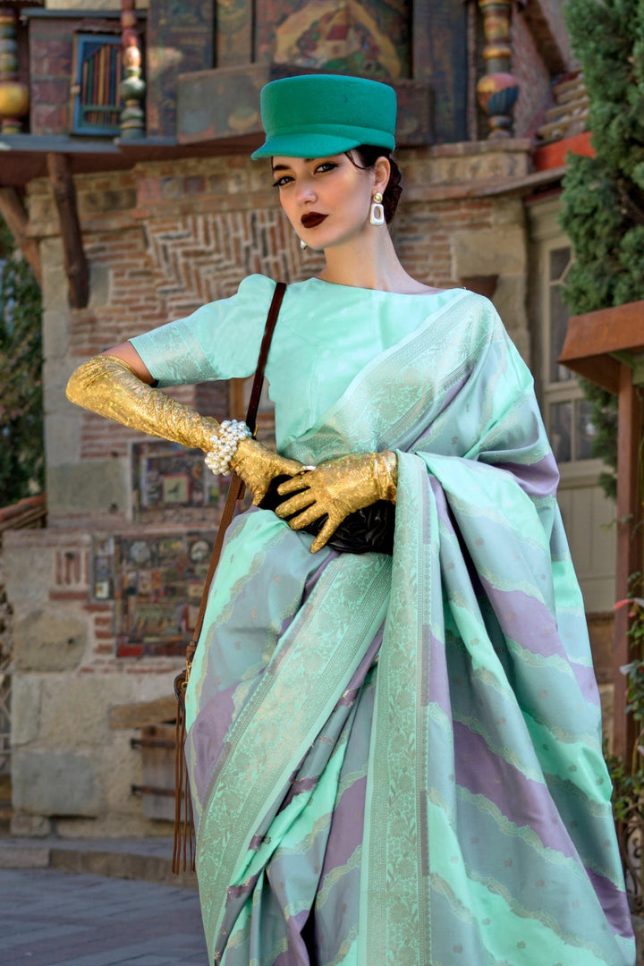 Mint and Mauve Kimbus saree in rangkaat katan silk, designed with wave-striped motifs and a dramatic tassel pallu. Best styled for sangeet and fashion-forward fusion ceremony celebrations. This image captures the side angle view showcasing blouse styling and zari border detail, ideal for visualizing festive elegance, designer appeal, and modern styling inspiration. Perfect for online shoppers seeking detailed previews before purchase, enhancing saree visual merchandising and SEO-rich product display strateg
