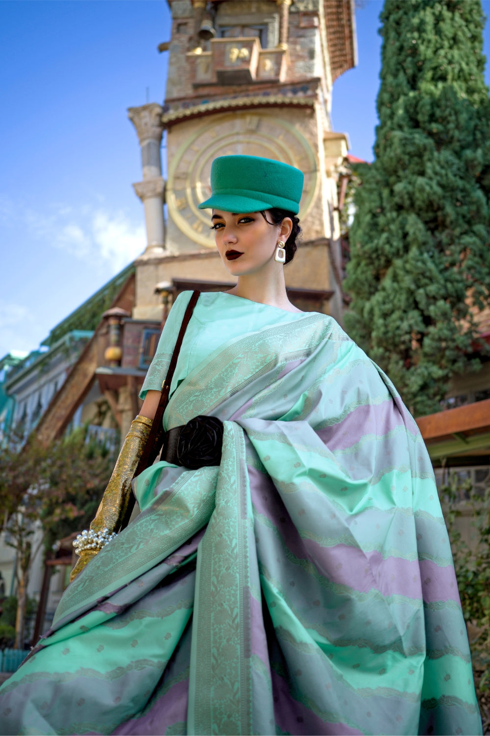 Mint and Mauve Kimbus saree in rangkaat katan silk, designed with wave-striped motifs and a dramatic tassel pallu. Best styled for sangeet and fashion-forward fusion ceremony celebrations. This image captures the model styling perspective with complete saree ensemble displayed, ideal for visualizing festive elegance, designer appeal, and modern styling inspiration. Perfect for online shoppers seeking detailed previews before purchase, enhancing saree visual merchandising and SEO-rich product display strateg