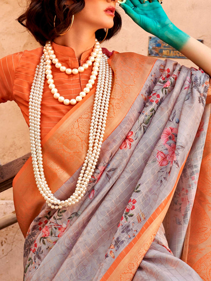 This Soft Grey–Burnt Orange FeatherSoft saree features stunning printed floral work with floral detailing and grid textures, ideal for festive evenings and cocktail-ready styling. Designed for lightweight elegance and statement draping. SKU 376002. This Soft Grey–Burnt Orange FeatherSoft saree features stunning printed floral work with floral detailing and grid textures, ideal for festive evenings and cocktail-ready styling. Designed for lightweight elegance and statement draping. SKU 376002.