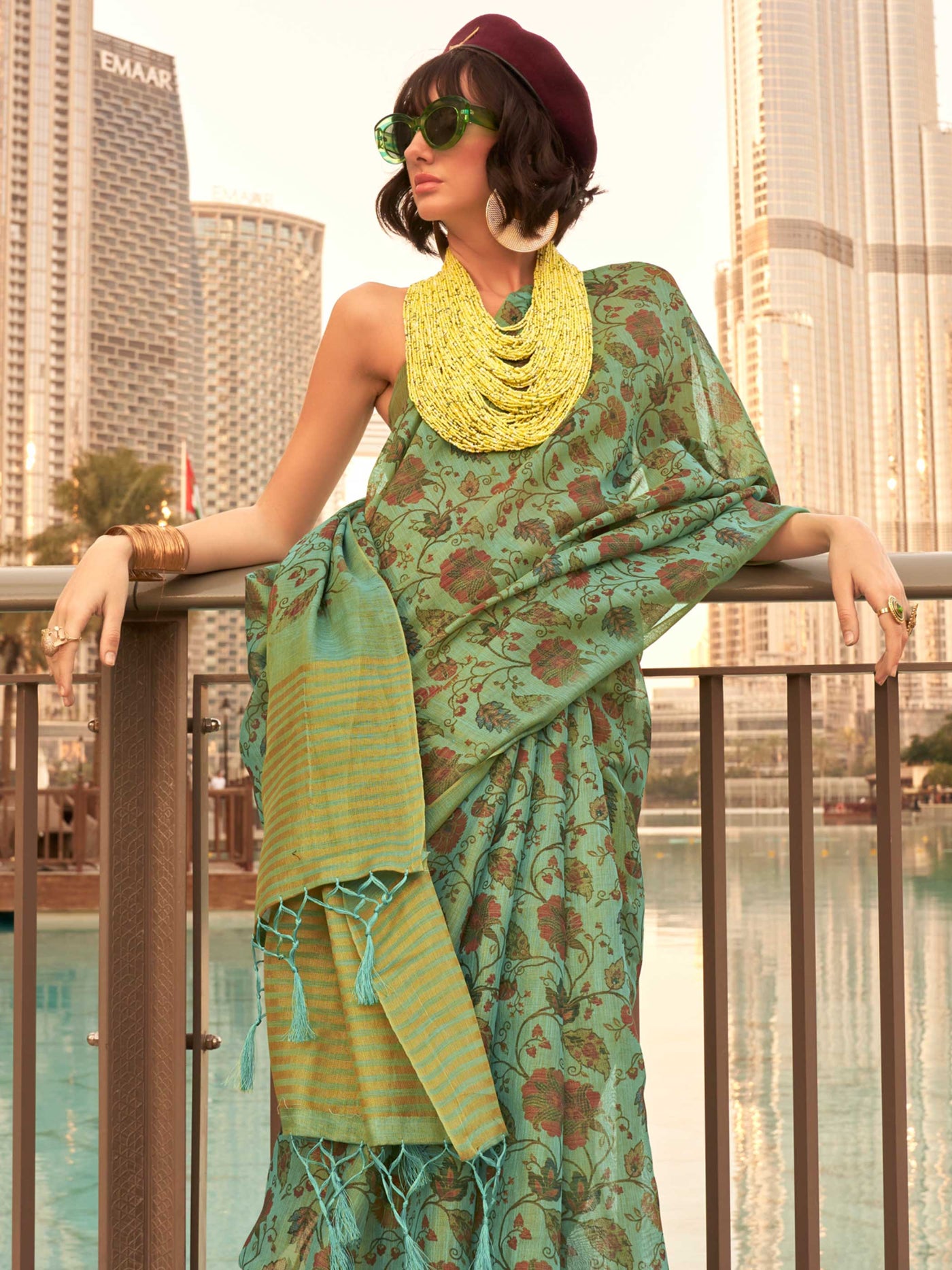 Sea Green and Golden zari tissue saree with printed floral motifs and zari pallu This image captures the side angle view showcasing blouse styling and zari border detail, ideal for visualizing festive elegance, designer appeal, and modern styling inspiration. Perfect for online shoppers seeking detailed previews before purchase, enhancing saree visual merchandising and SEO-rich product display strategy.                                                                                                          