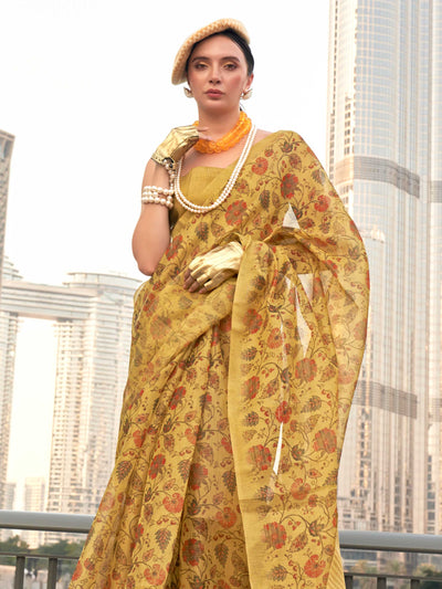 Yellow and Burnt Orange zari tissue saree with printed floral motifs and zari pallu This image captures the side angle view showcasing blouse styling and zari border detail, ideal for visualizing festive elegance, designer appeal, and modern styling inspiration. Perfect for online shoppers seeking detailed previews before purchase, enhancing saree visual merchandising and SEO-rich product display strategy.                                                                                                       