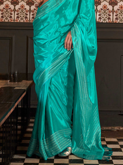 Photographed in a neutral studio with ambient shadows to highlight the zari’s glimmer and the weave’s detail