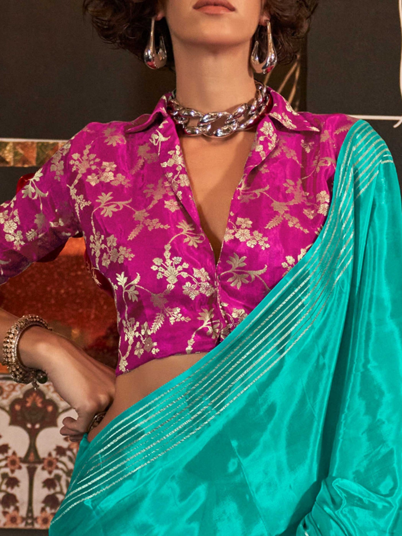 This saree pairs well with metallic jewelry and soft curls or a sleek bun