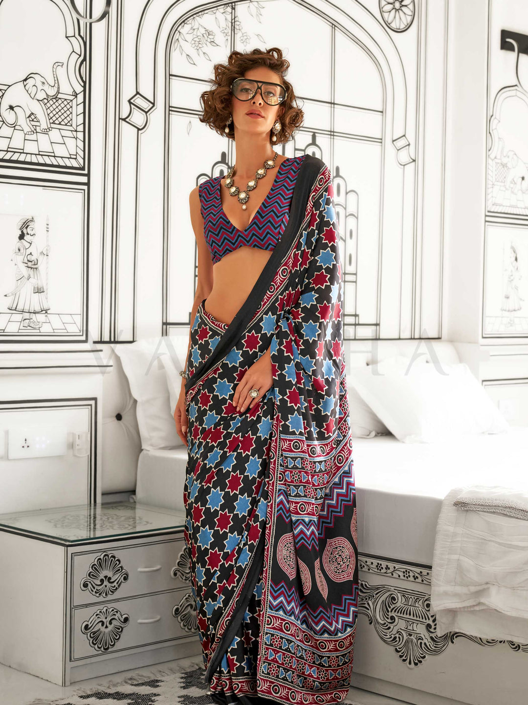 Black and Blue-Red satin crepe saree with ajrakh digital print, soft texture and festive drape This image captures the front drape view highlighting pallu fall and pleats alignment, ideal for visualizing festive elegance, designer appeal, and modern styling inspiration. Perfect for online shoppers seeking detailed previews before purchase, enhancing saree visual merchandising and SEO-rich product display strategy.                                                                                               