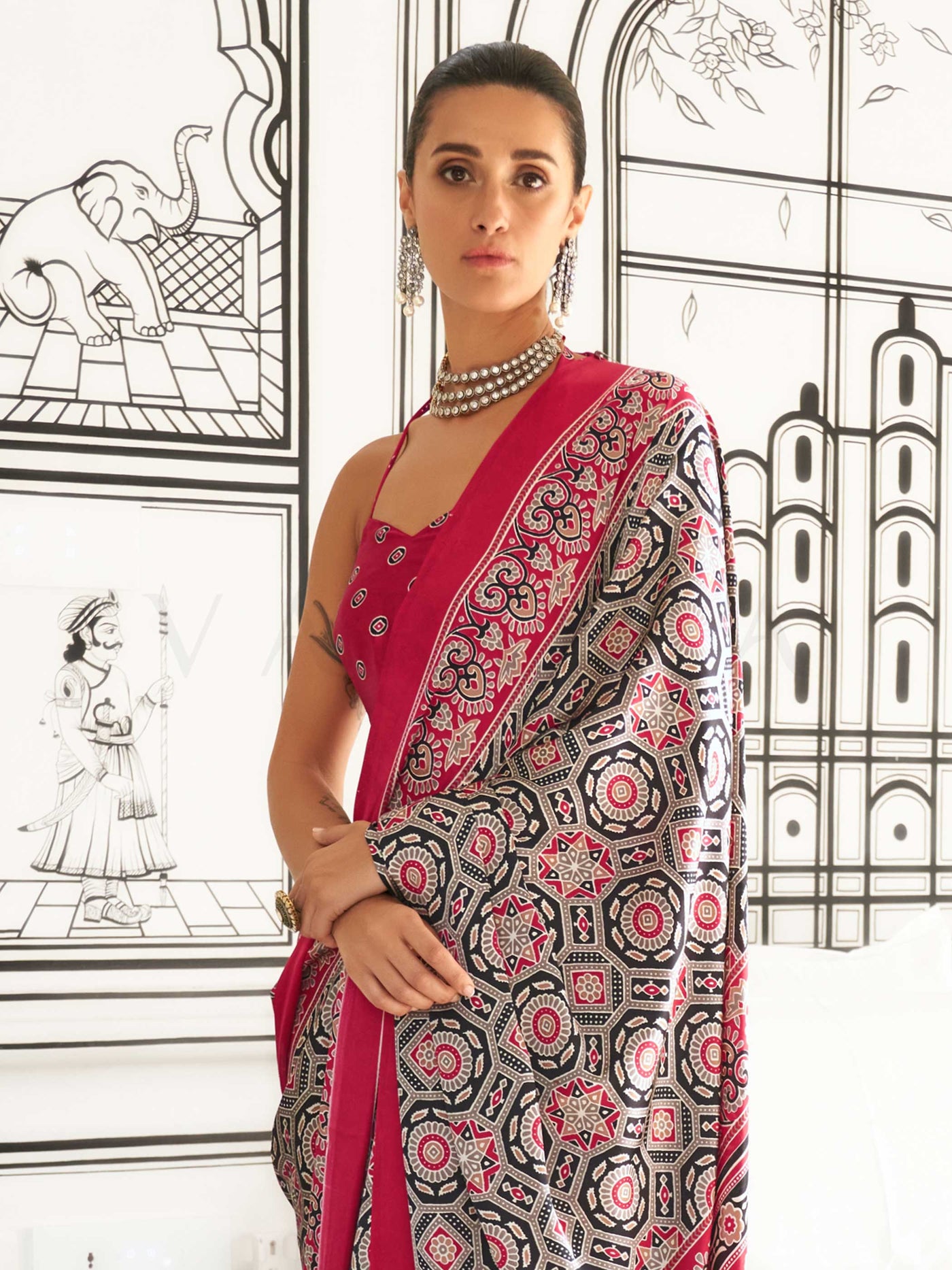 Red and Black-White satin crepe saree with ajrakh digital print, soft texture and festive drape This image captures the side angle view showcasing blouse styling and zari border detail, ideal for visualizing festive elegance, designer appeal, and modern styling inspiration. Perfect for online shoppers seeking detailed previews before purchase, enhancing saree visual merchandising and SEO-rich product display strategy.                                                                                           