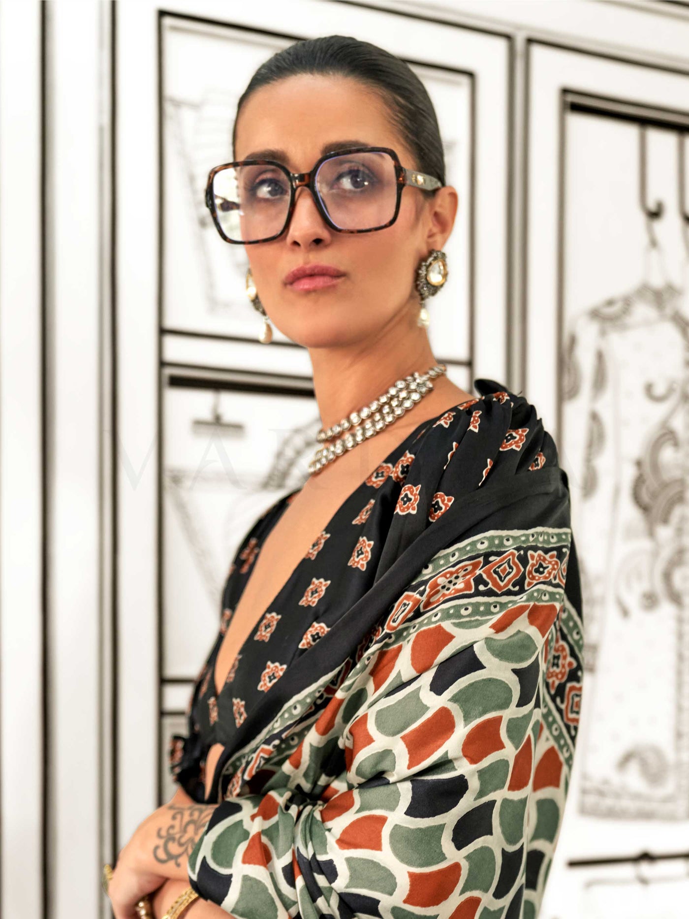 Black and Olive-Red satin crepe saree with ajrakh digital print, soft texture and festive drape This image captures the model styling perspective with complete saree ensemble displayed, ideal for visualizing festive elegance, designer appeal, and modern styling inspiration. Perfect for online shoppers seeking detailed previews before purchase, enhancing saree visual merchandising and SEO-rich product display strategy.                                                                                           