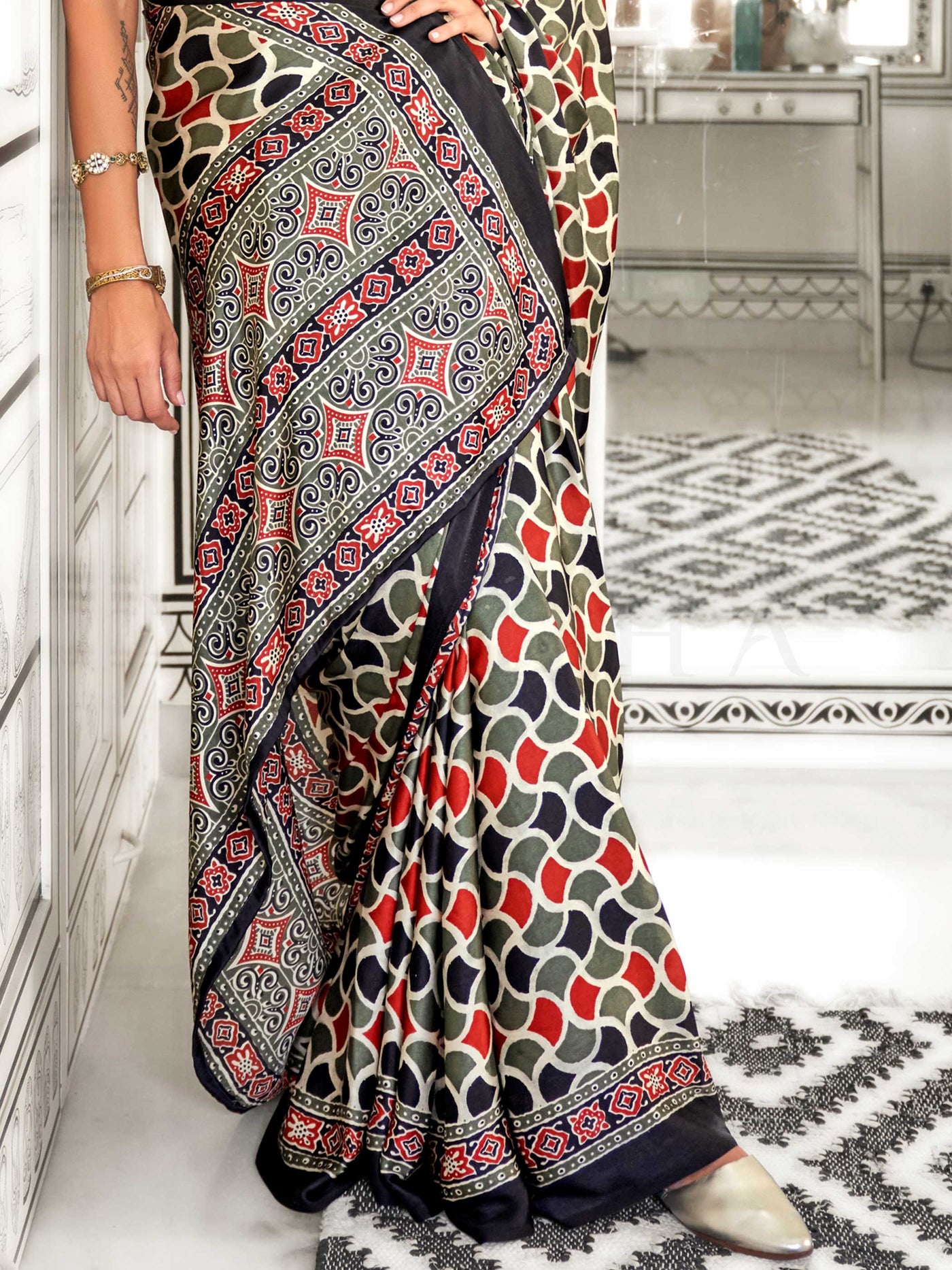 Black and Olive-Red satin crepe saree with ajrakh digital print, soft texture and festive drape This image captures the back drape focus revealing pallu finesse and motif richness, ideal for visualizing festive elegance, designer appeal, and modern styling inspiration. Perfect for online shoppers seeking detailed previews before purchase, enhancing saree visual merchandising and SEO-rich product display strategy.                                                                                                