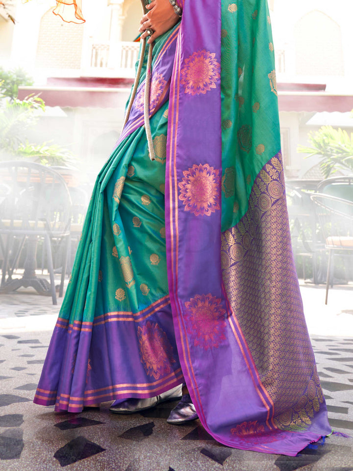 Artful Emerald Green–Purple satin silk fabric with mandala buttas and contrast blouse pairing idea. Emerald Green–Purple ethnic saree styled for parties, featuring woven motifs and soft luminous shine.