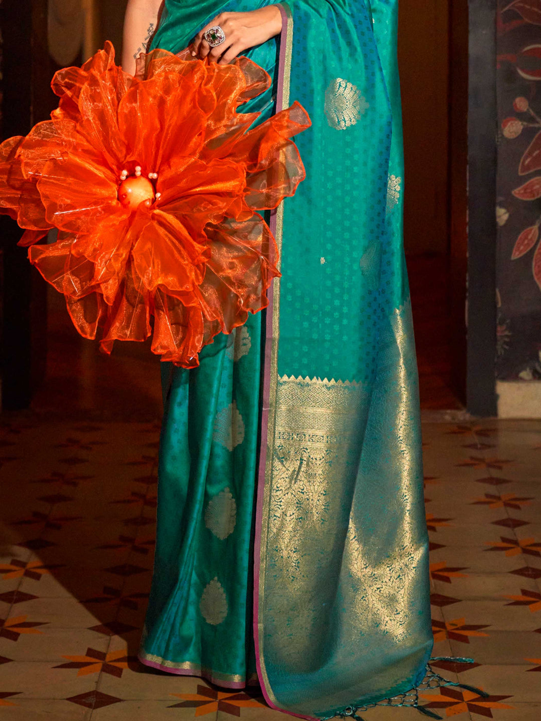 Banarasi satin saree in Teal Blue–Gold styled with heirloom jewelry and festive decor. Ornate pallu with golden motifs set against Teal Blue–Gold satin silk for regal presence..