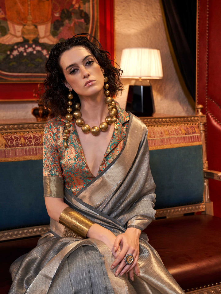 Soft Silver Grey chiffon saree with Platinum pallu and zari accents This image captures the model styling perspective with complete saree ensemble displayed, ideal for visualizing festive elegance, designer appeal, and modern styling inspiration. Perfect for online shoppers seeking detailed previews before purchase, enhancing saree visual merchandising and SEO-rich product display strategy.                                                                                                                       
