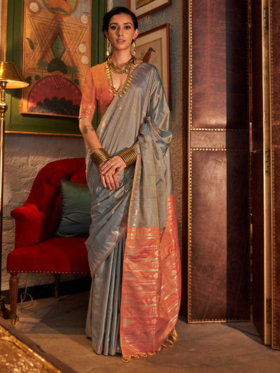 Powder Blue–Copper Peach feathersoft raw silk saree featuring banarasi ikat design, ideal for sangeet night and festive evening wear with rich texture and contrast blouse. Powder Blue–Copper Peach feathersoft raw silk saree featuring banarasi ikat design, ideal for sangeet night and festive evening wear with rich texture and contrast blouse..