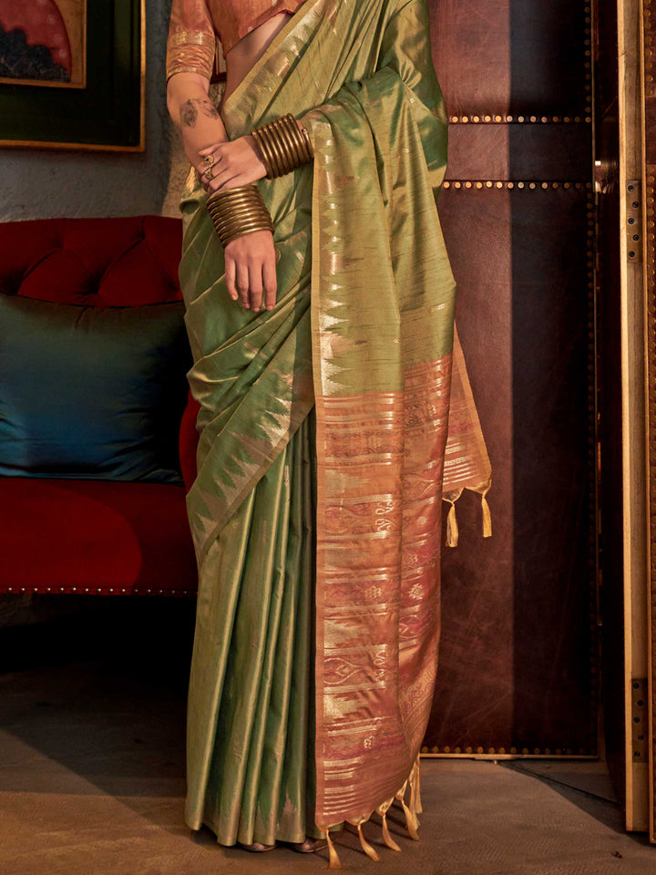 Olive Green–Dusky Rose feathersoft raw silk saree featuring banarasi ikat design, ideal for sangeet night and festive evening wear with rich texture and contrast blouse. Olive Green–Dusky Rose feathersoft raw silk saree featuring banarasi ikat design, ideal for sangeet night and festive evening wear with rich texture and contrast blouse..