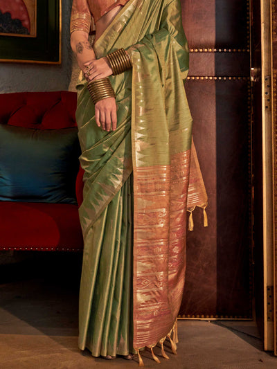 Olive Green–Dusky Rose feathersoft raw silk saree featuring banarasi ikat design, ideal for sangeet night and festive evening wear with rich texture and contrast blouse. Olive Green–Dusky Rose feathersoft raw silk saree featuring banarasi ikat design, ideal for sangeet night and festive evening wear with rich texture and contrast blouse..