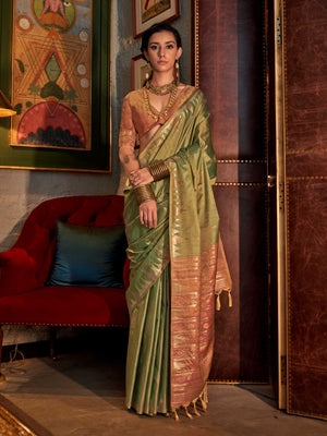 Olive Green–Dusky Rose feathersoft raw silk saree featuring banarasi ikat design, ideal for sangeet night and festive evening wear with rich texture and contrast blouse. Olive Green–Dusky Rose feathersoft raw silk saree featuring banarasi ikat design, ideal for sangeet night and festive evening wear with rich texture and contrast blouse..