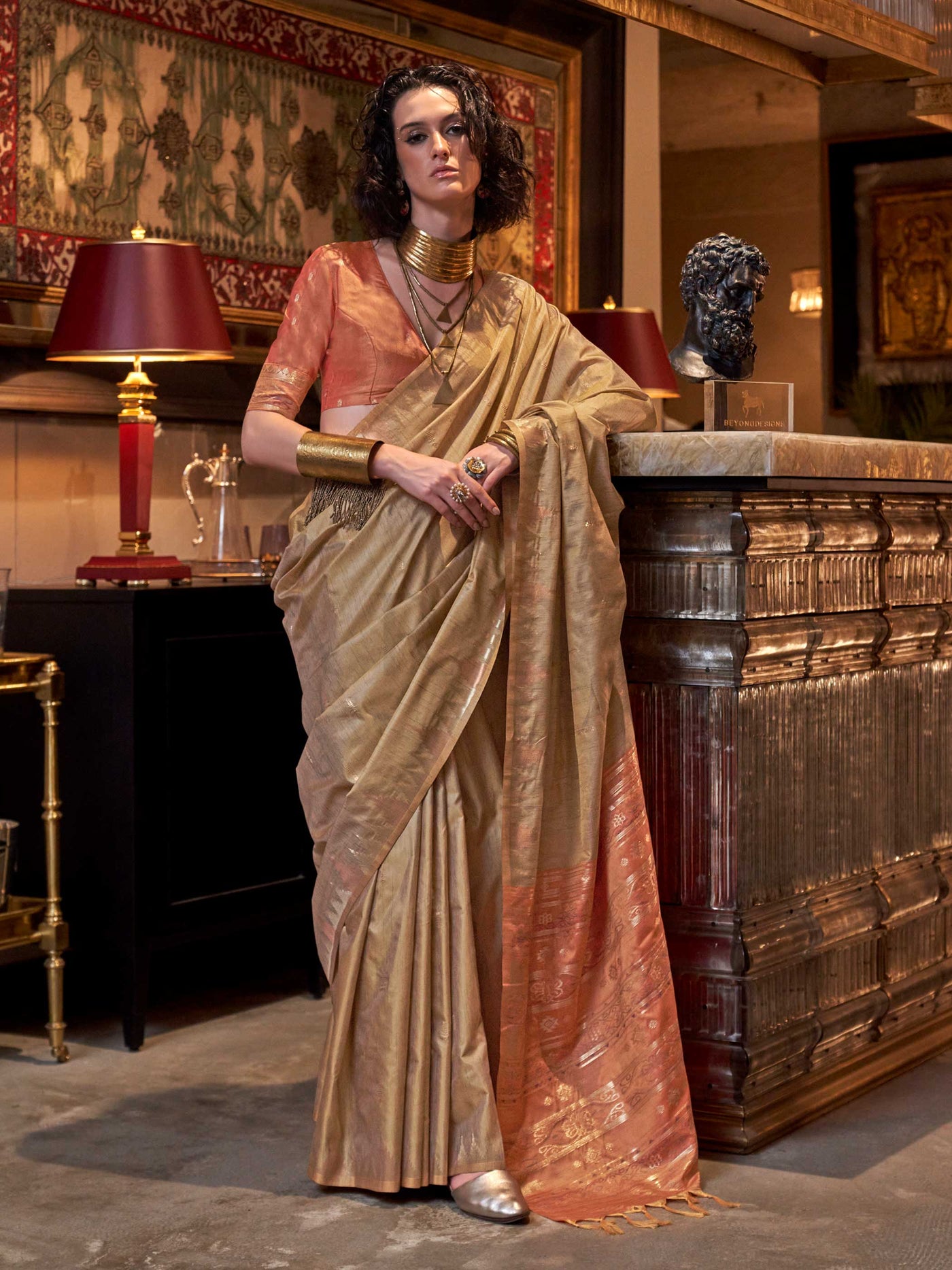 Beige Gold–Rust Copper feathersoft raw silk saree featuring banarasi ikat design, ideal for sangeet night and festive evening wear with rich texture and contrast blouse. Beige Gold–Rust Copper feathersoft raw silk saree featuring banarasi ikat design, ideal for sangeet night and festive evening wear with rich texture and contrast blouse..