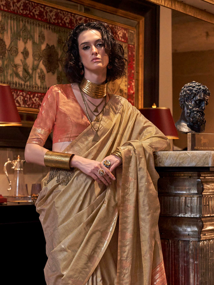Beige Gold–Rust Copper feathersoft raw silk saree featuring banarasi ikat design, ideal for sangeet night and festive evening wear with rich texture and contrast blouse. Beige Gold–Rust Copper feathersoft raw silk saree featuring banarasi ikat design, ideal for sangeet night and festive evening wear with rich texture and contrast blouse..