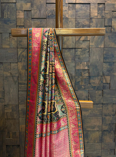 Colorful patterned saree draped over a wooden cross against a textured wall.