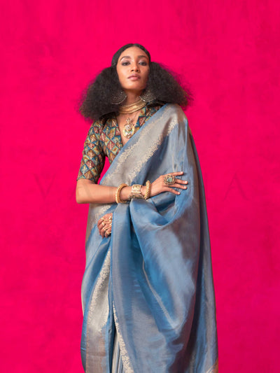 Stone Blue–Silver Zari tissue viscose silk saree with jacquard woven zari work, ideal for weddings, bridesmaids, and elegant evening events. Features tassel border and shimmering finish. Stone Blue–Silver Zari tissue viscose silk saree with jacquard woven zari work, ideal for weddings, bridesmaids, and elegant evening events. Features tassel border and shimmering finish..