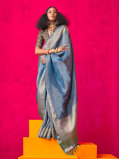 Stone Blue–Silver Zari tissue viscose silk saree with jacquard woven zari work, ideal for weddings, bridesmaids, and elegant evening events. Features tassel border and shimmering finish. Stone Blue–Silver Zari tissue viscose silk saree with jacquard woven zari work, ideal for weddings, bridesmaids, and elegant evening events. Features tassel border and shimmering finish..